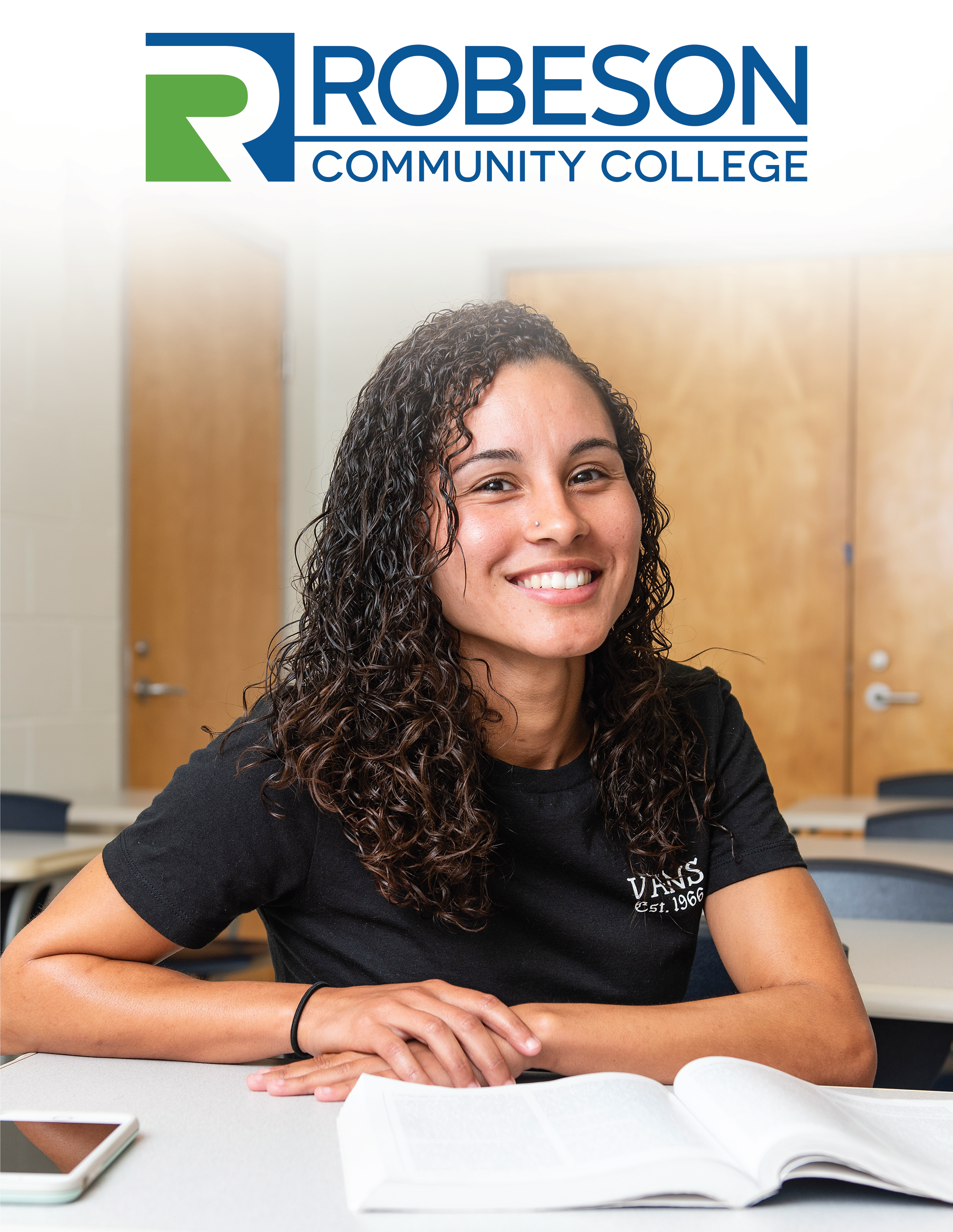 Robeson Community College Logo with printed text "2019-2020 Academic Catalog and Student Handbook" and image of a young, smiling female at a desk with an open text book.